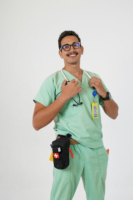 A man in a green scrub suit holding a toothbrush
